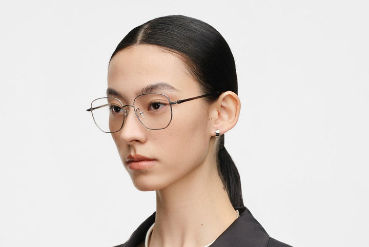 Model wearing MUJOSH ultra-lightweight titanium glasses, thin metal frame, profile view