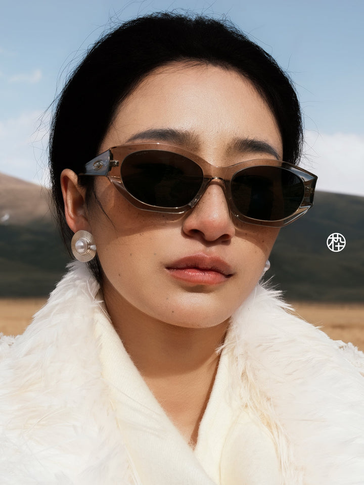 Woman wearing MUJOSH angular cat eye sunglasses in translucent brown acetate